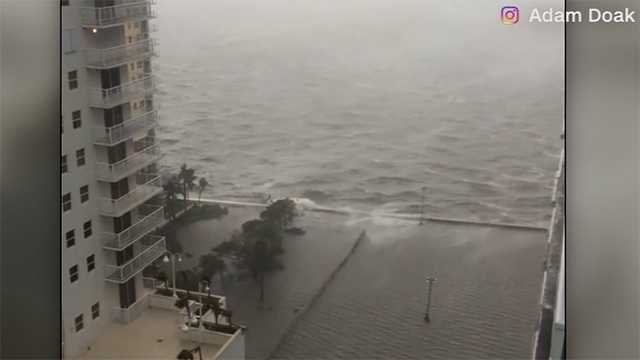 Waves crash by downtown Miami as streets flood