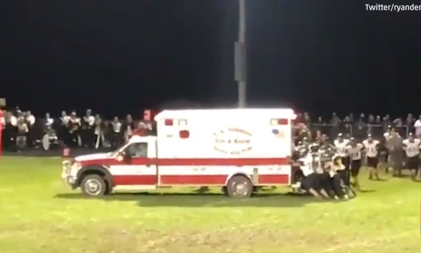 Watch: Football team pushes stuck ambulance off field