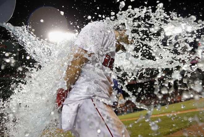 Boston Red Sox's Andrew Benintendi gets doused after hitting the game-winning RBI single during the tenth inning of a baseball game against the New York Yankees in Boston, Monday, Aug. 6, 2018. (AP Photo/Michael Dwyer)