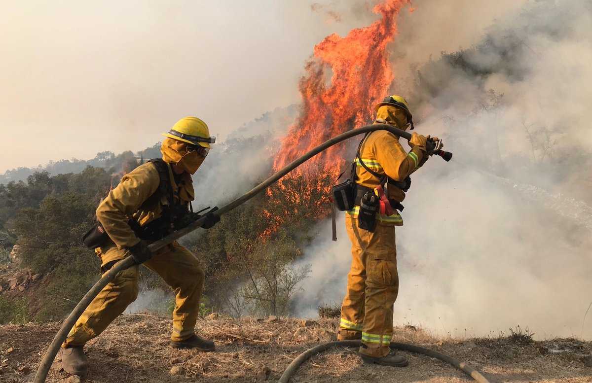 Flames threaten coastal communities as firefighters mourn