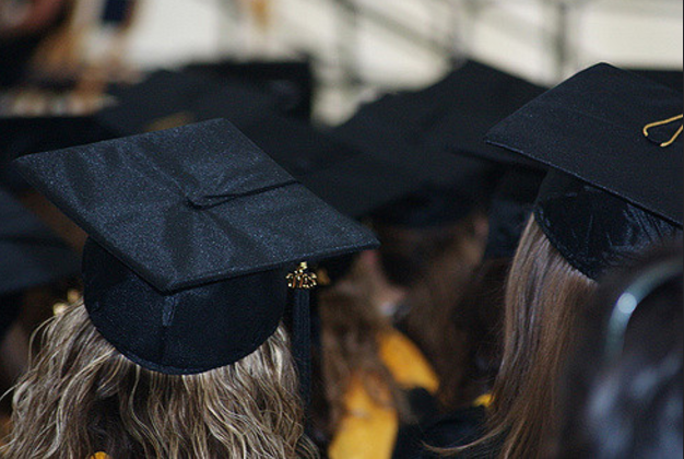 Daughter accepts high school diploma from Air Force father