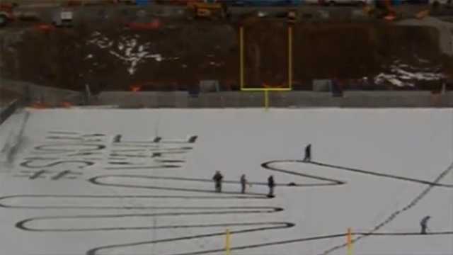 Giant hand takes shape in snow at college football stadium