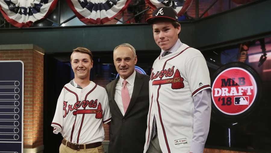 Carter Stewart, a pitcher from Eau Gallie High School in Florida, right, poses for photos with Baseball commissioner Rob Manfred, center, and Luke Terry, left, after being selected eighth by the Atlanta Braves during the first round of the Major League Baseball draft Monday, June 4, 2018, in Secaucus, N.J. 