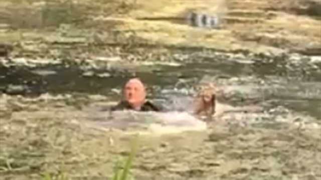 Officer jumps into lagoon to save struggling dog