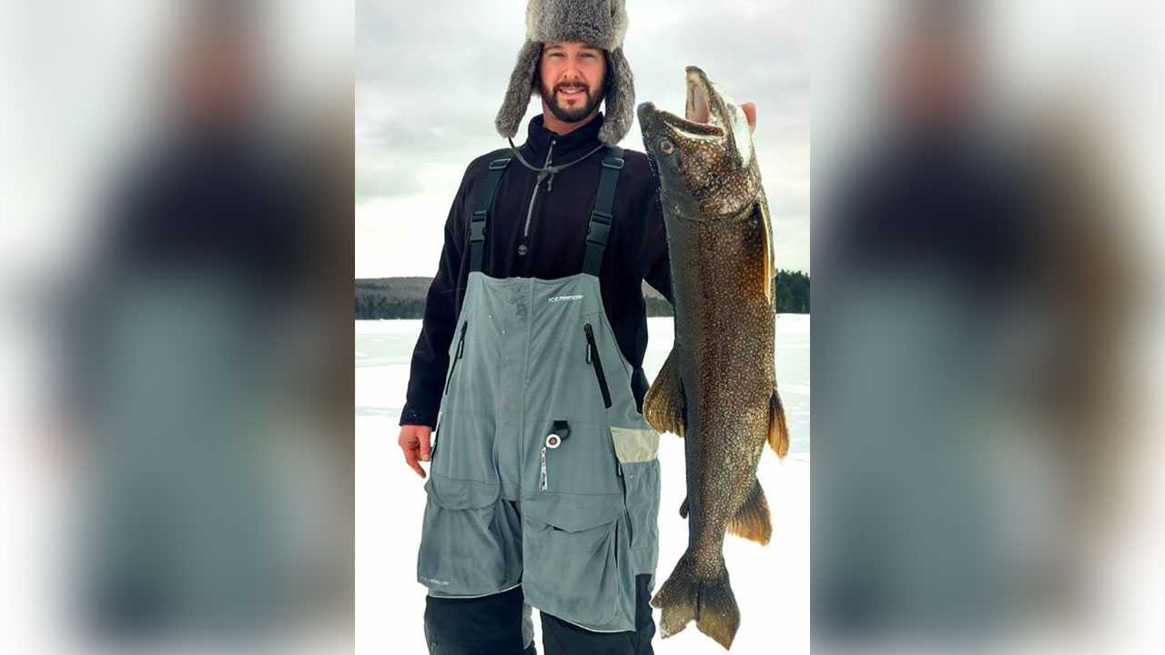 Ice fisherman struggles to reel in lake trout due to its huge size