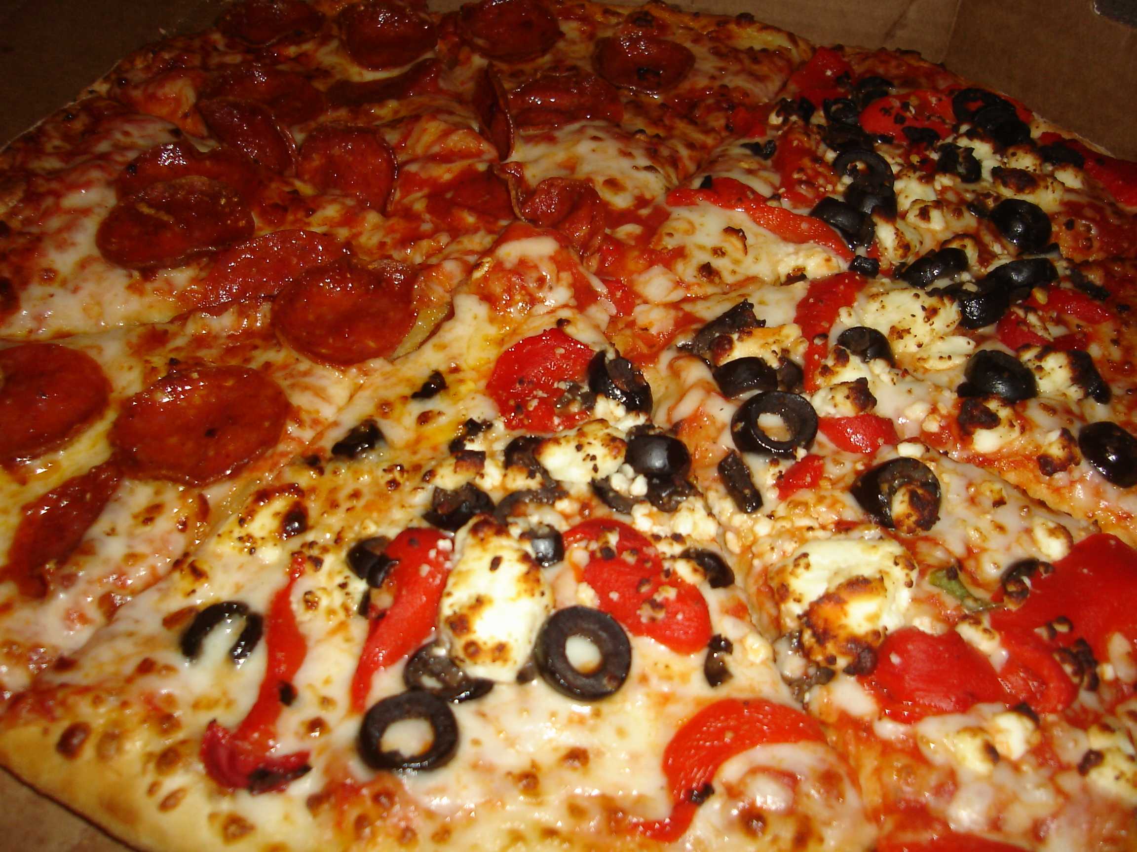 A Domino's employee walks to deliver pizzas after his car breaks down