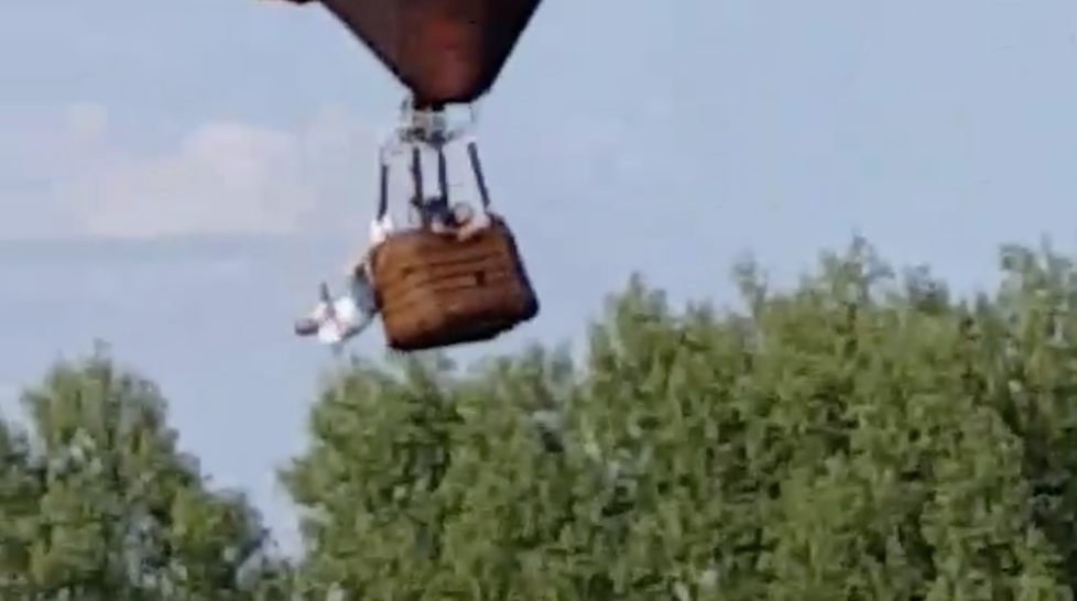 Watch a man dangle from a hot air balloon