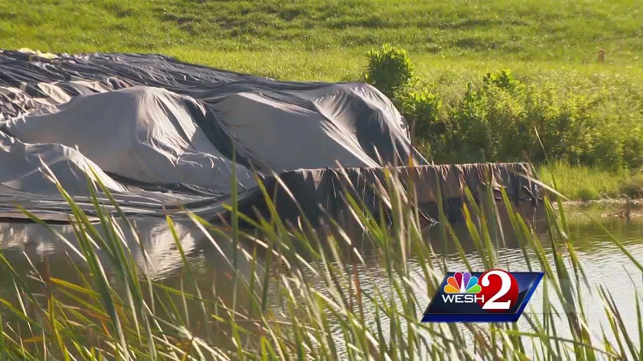 Hot air balloon crashes into pond, trapping riders under plastic